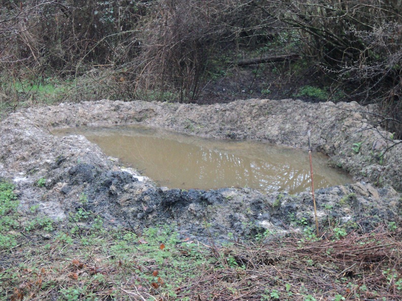 La mare fraichement creusée en mars 2018.<br />Les traces noires sont certainement le souvenir des charbons de bois issus de l'alambic qui fonctionnait dans le vallon au siècle dernier.