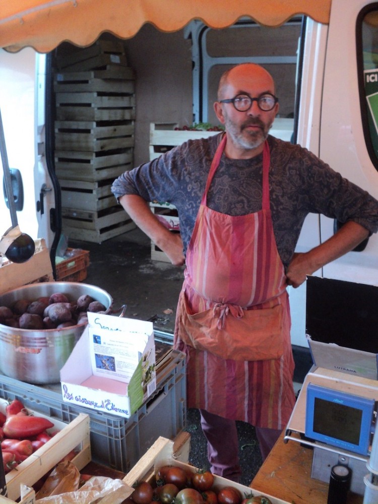 Etienne en tenue de marché et la boite présentoir devant lui