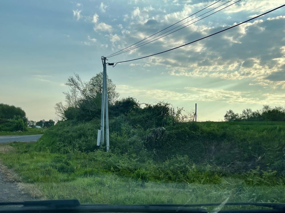 En face, la limite du rond point avec l'A84 qui hésite entre haie et buissons