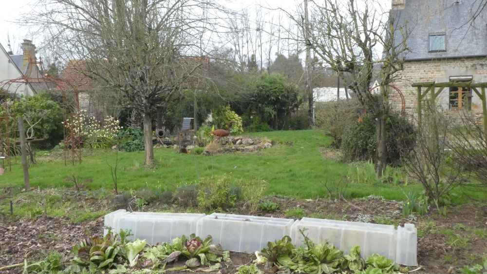 La maison d'habitation et, à gauche, des refuges pour moineaux et étourneaux, le potager et une petite mare.