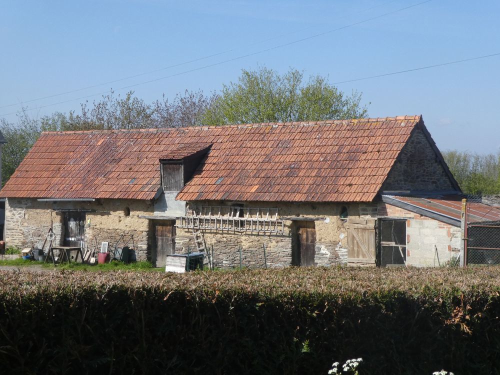 Dans le hameau de Martinville, ce bâtiment traditionnel est le domaine de quelques moineaux qui profitent ici d'une petite basse-cour.