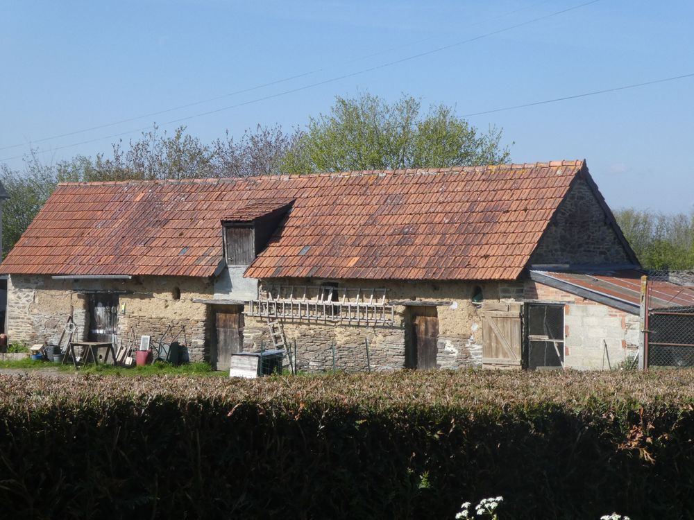 Dans le hameau de Martinville, ce bâtiment traditionnel  est le domaine de quelques moineaux qui profitent ici d'une petite basse-cour.
